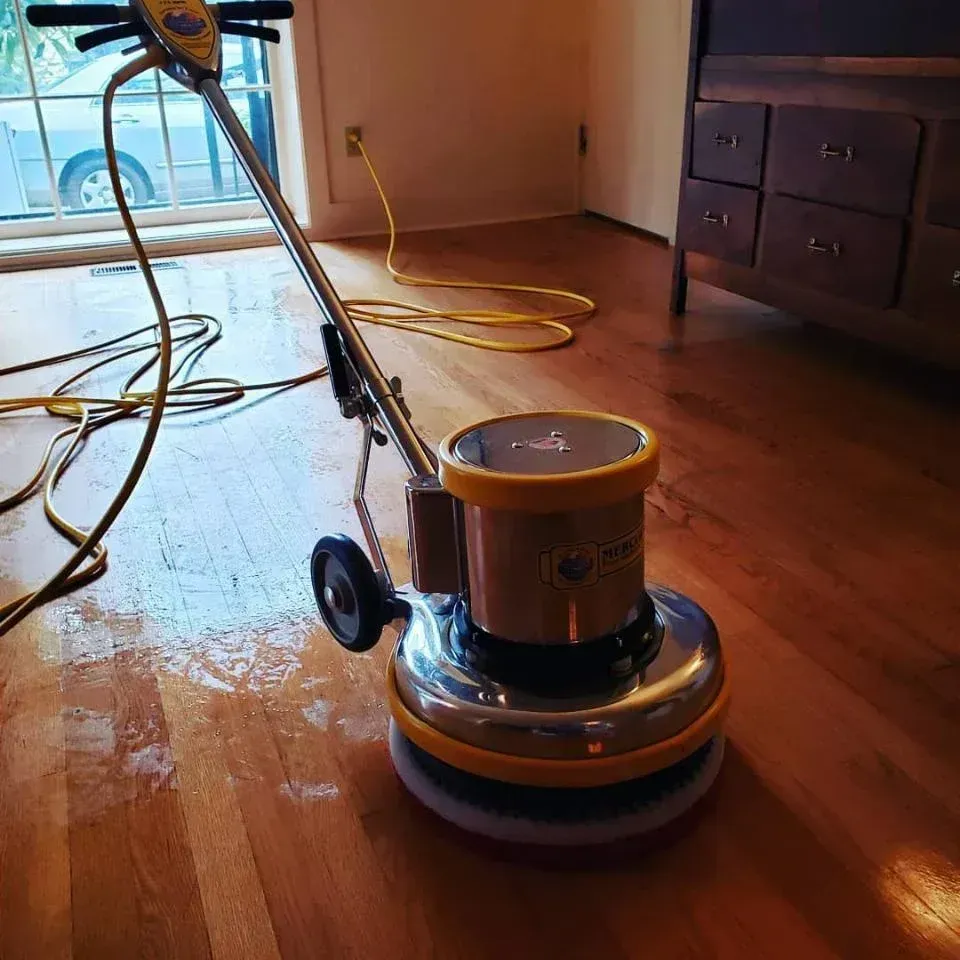 A vacuum cleaner is sitting on a wooden floor in a room.