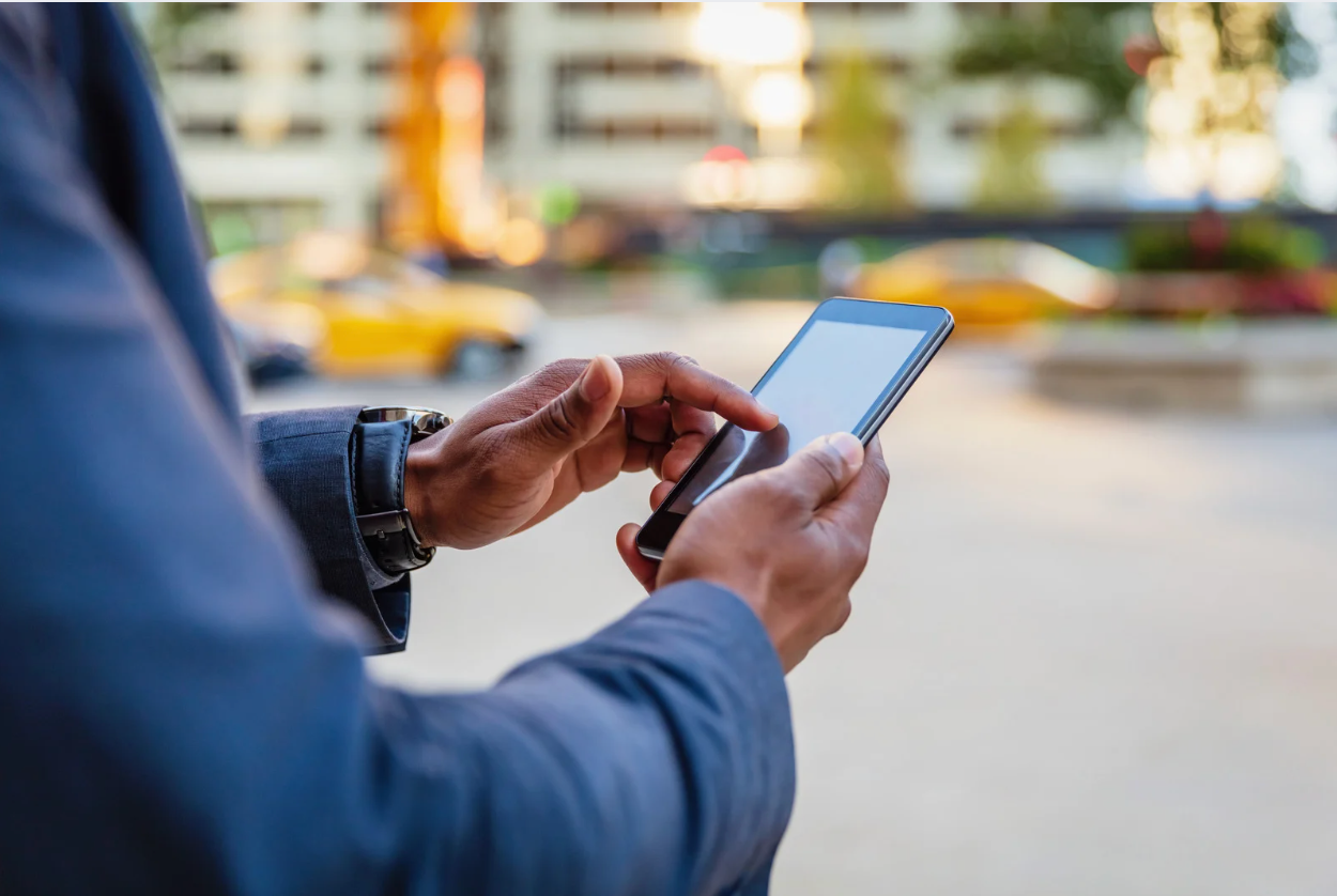 Image of man ordering ride on ridesharing app like Uber or Lyft.