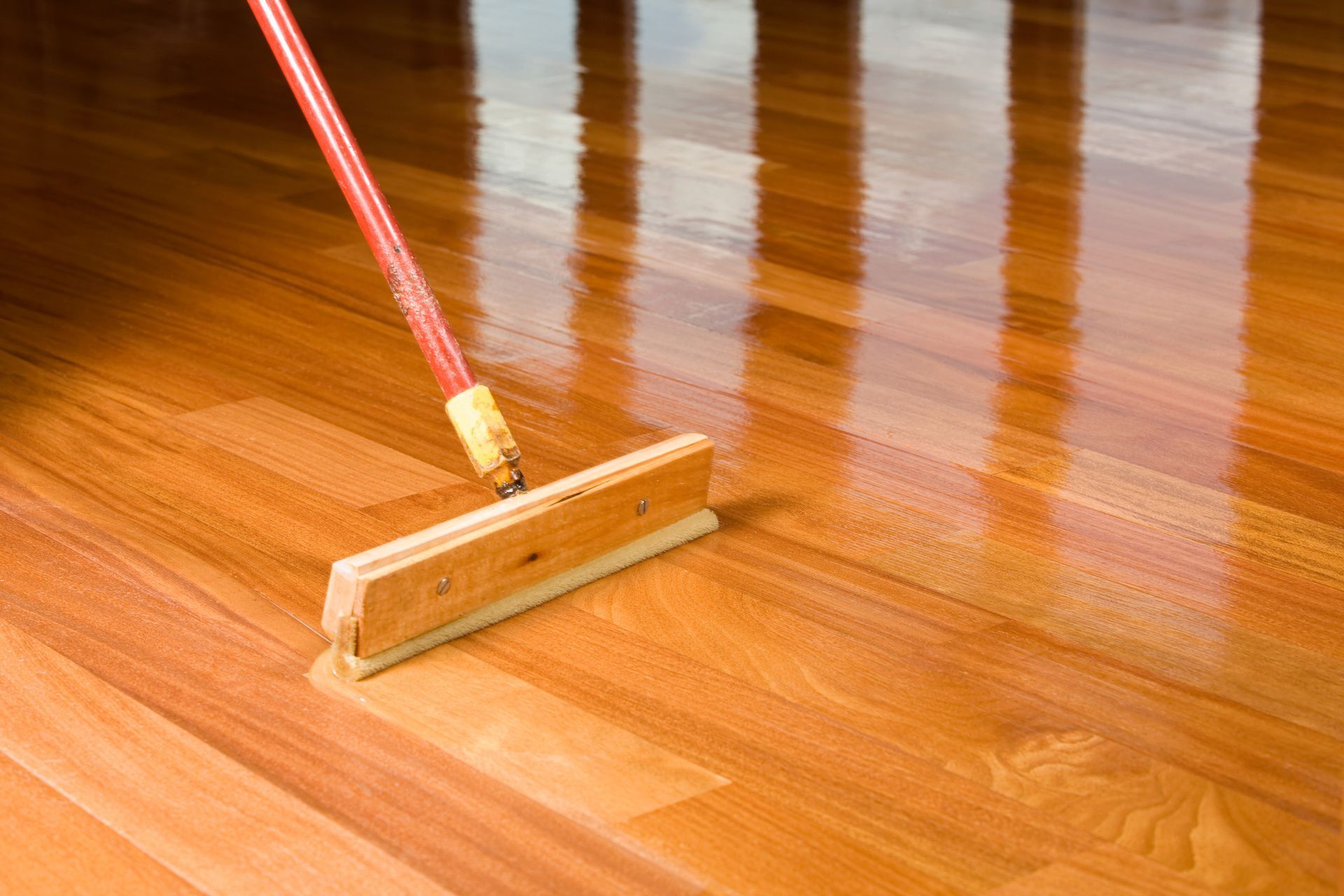 A person is polishing a wooden floor with a mop.
