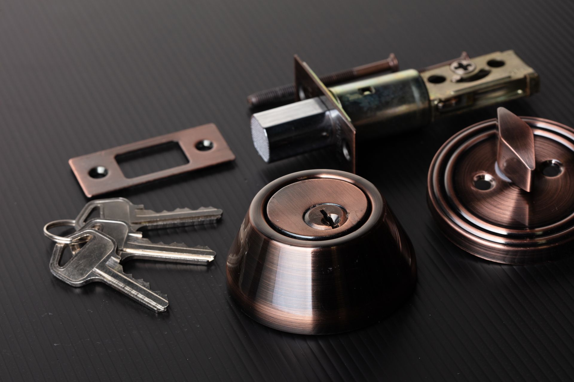 A close up of a door lock with keys on a table.