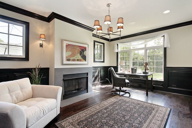 A living room with a couch , chair , desk and fireplace.