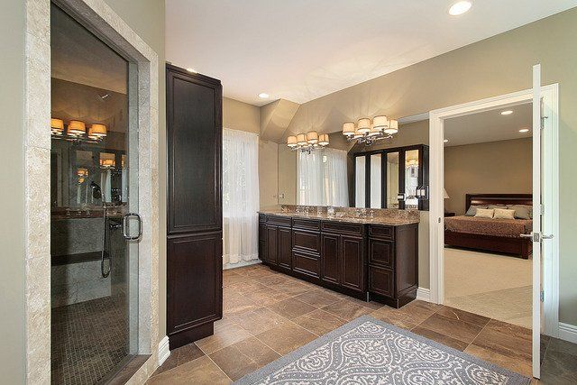 A bathroom with two sinks , a large mirror , and a walk in shower.