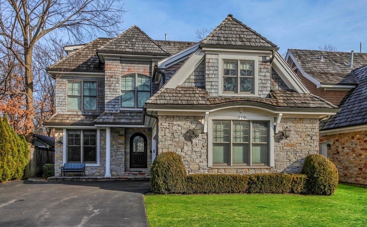 A large brick house with a shingle roof is for sale.