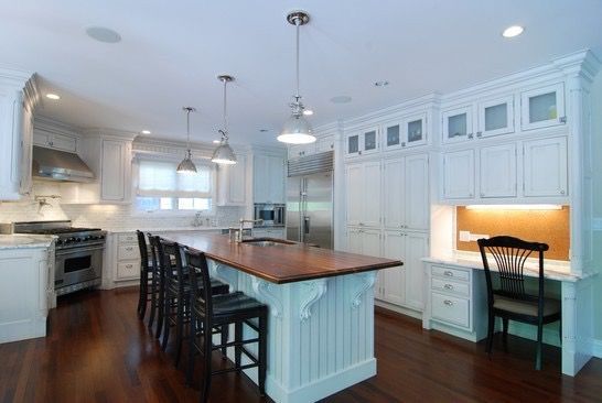 A kitchen with white cabinets and a large island