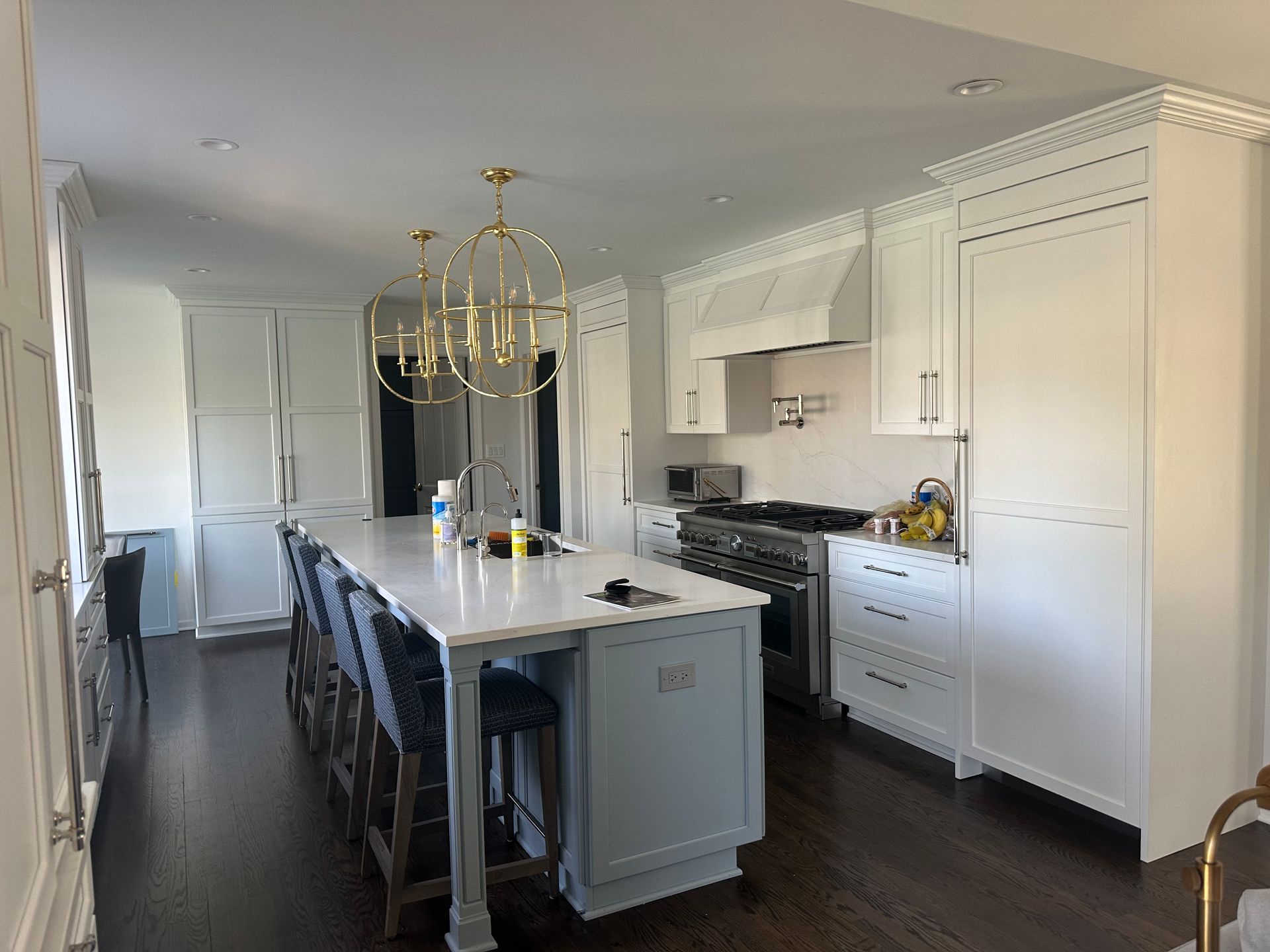 A kitchen with white cabinets and a large island in the middle.