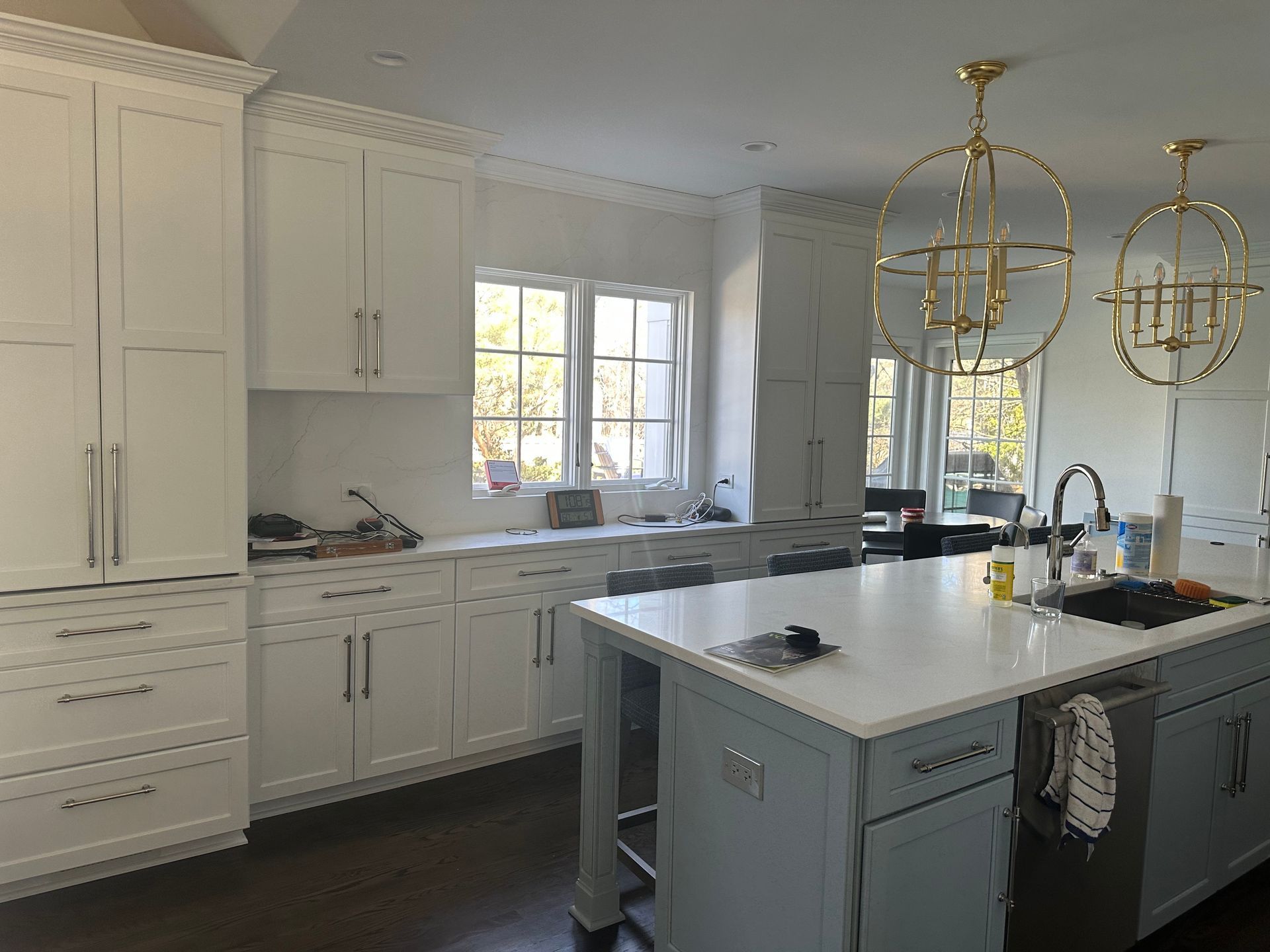 A kitchen with white cabinets and a large island in the middle.