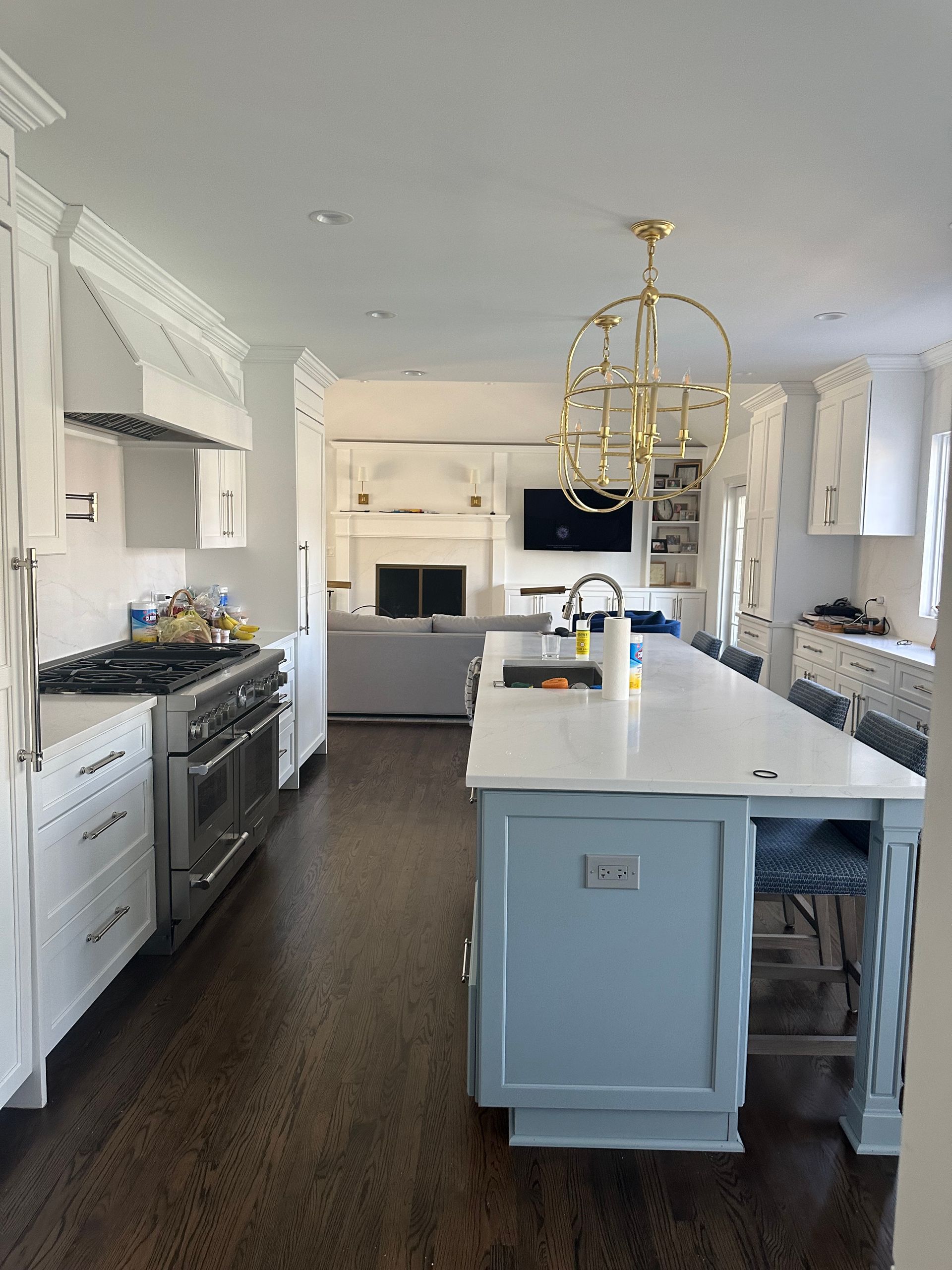 A kitchen with a large island in the middle and a chandelier hanging from the ceiling.