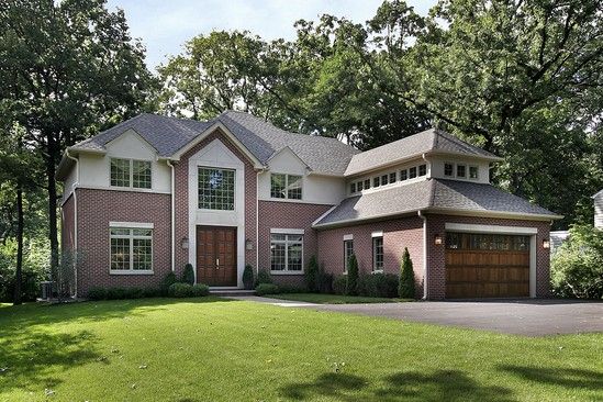 A large brick house with a brown garage door