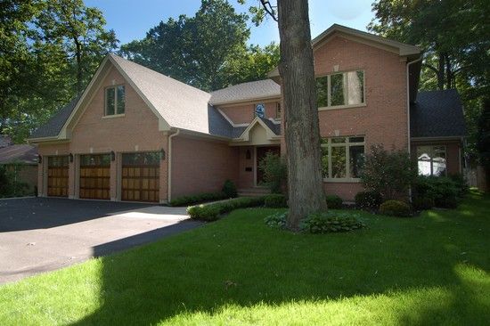 A large brick house with a tree in front of it
