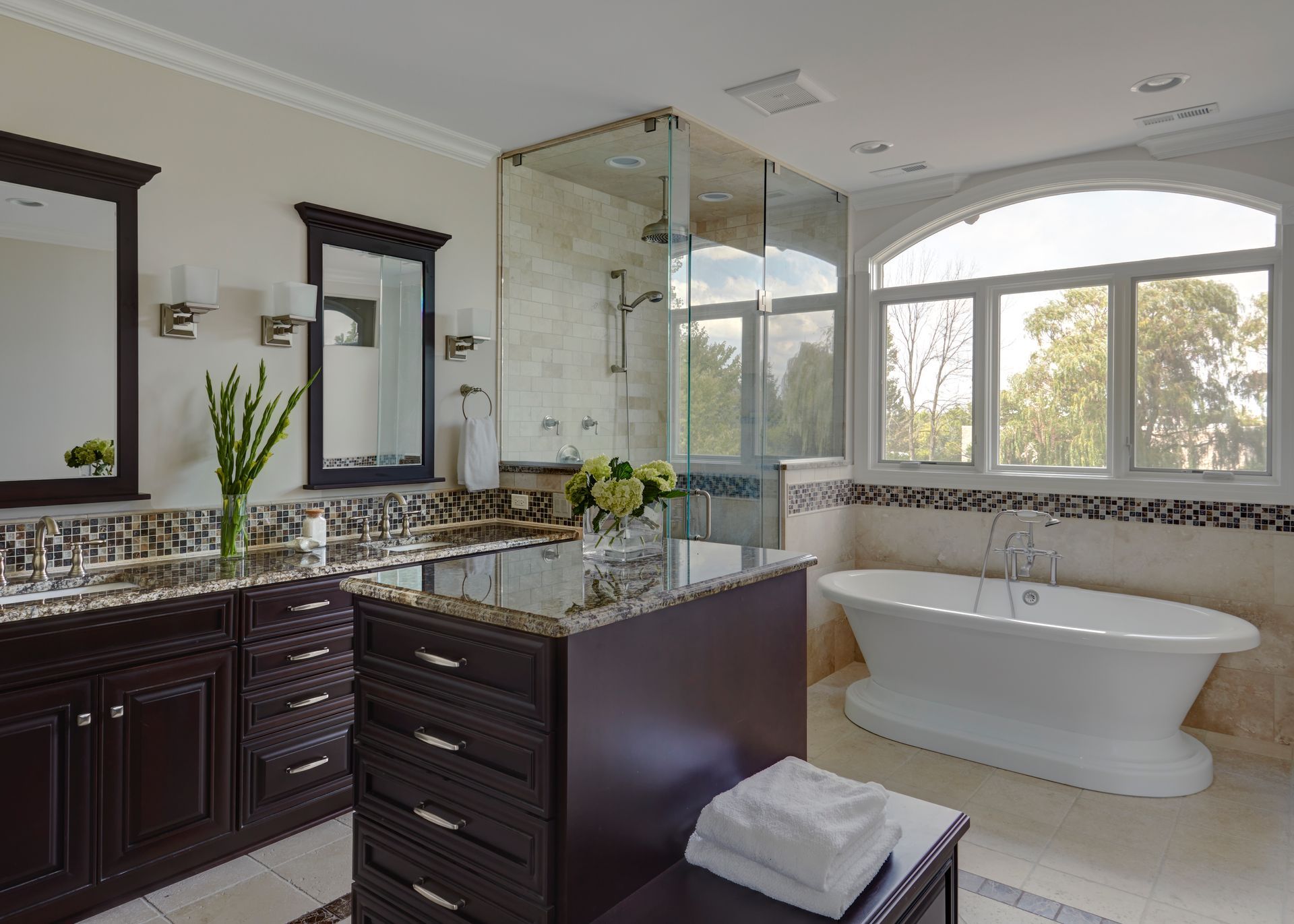 A bathroom with two sinks , a tub , and a walk in shower.