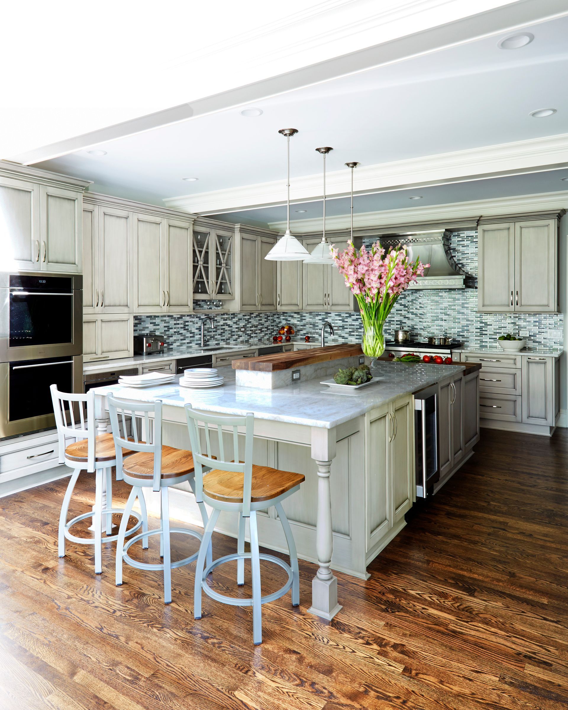 A kitchen with black cabinets and white counter tops and a dining room with a table and chairs.