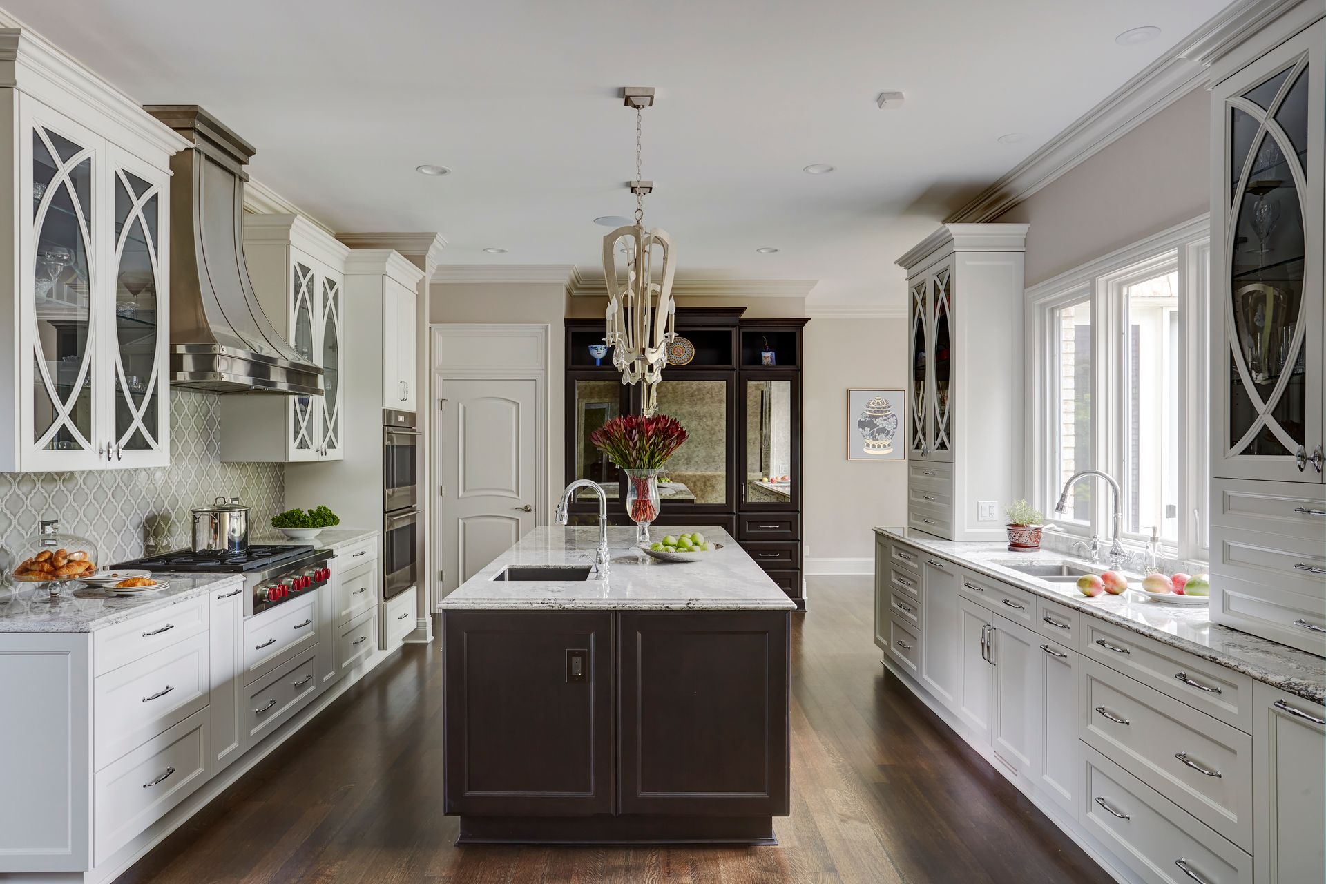 A kitchen with white cabinets and a large island in the middle.