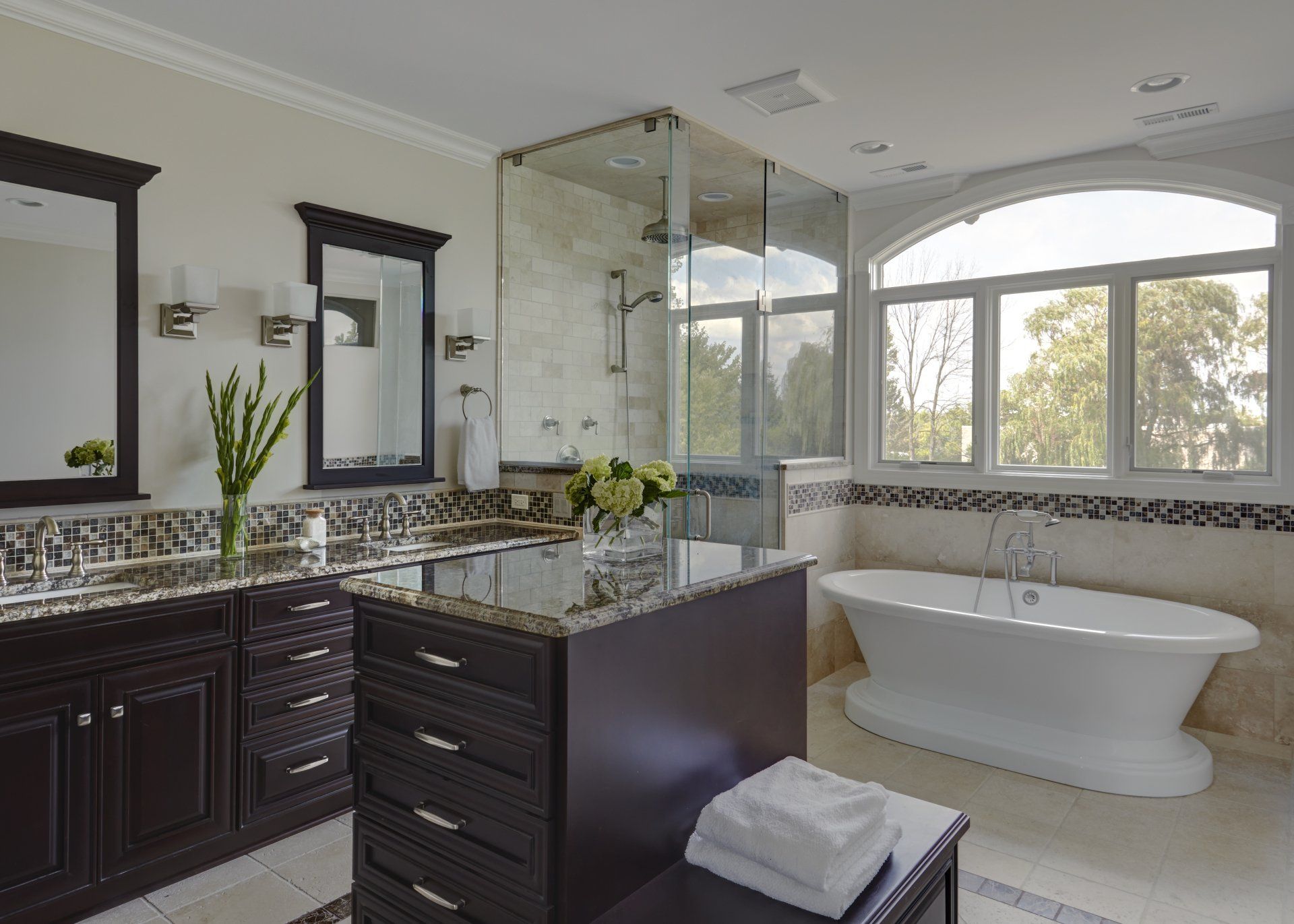 A bathroom with two sinks , a tub and a shower.