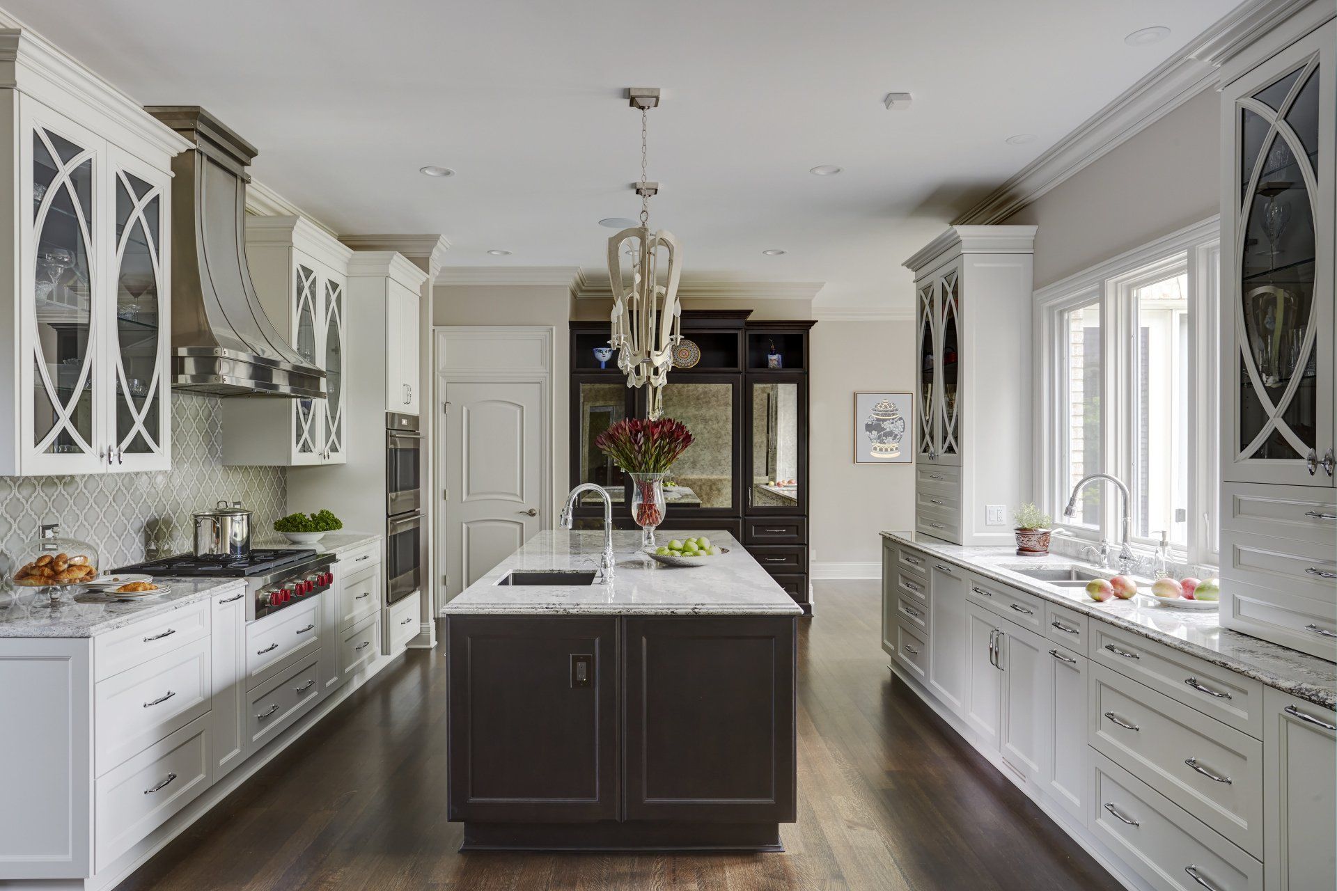 A kitchen with white cabinets and a large island in the middle.