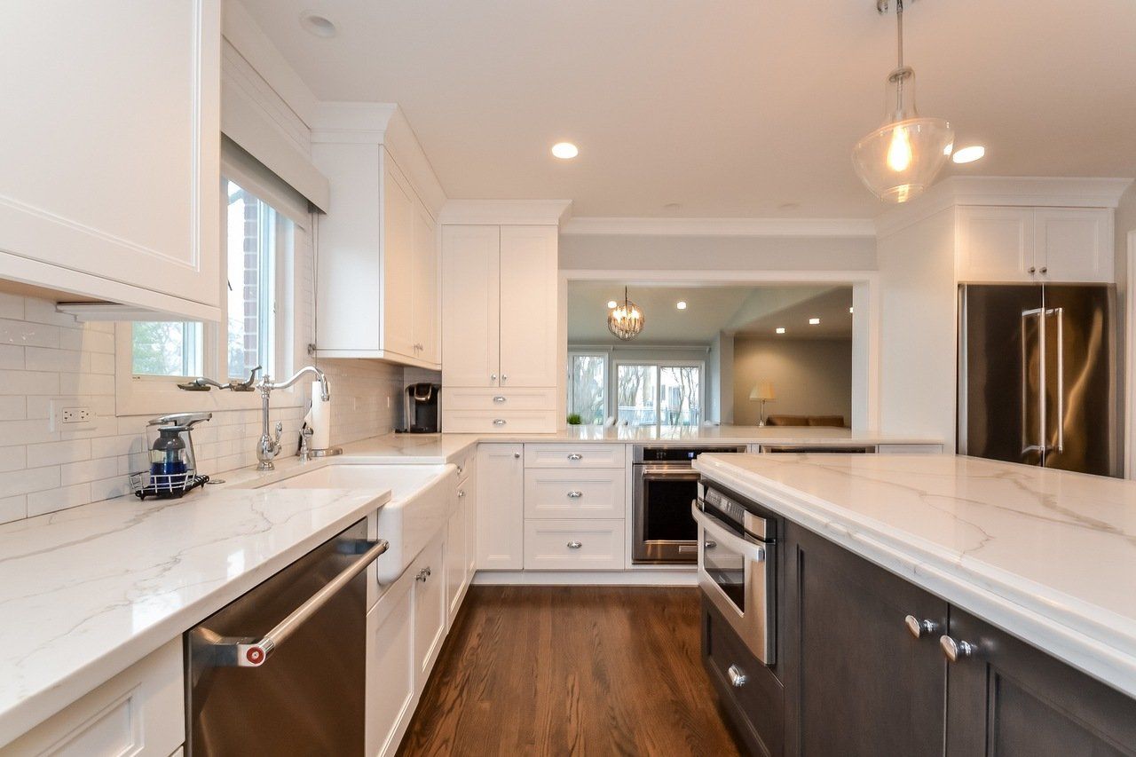 A kitchen with white cabinets and stainless steel appliances