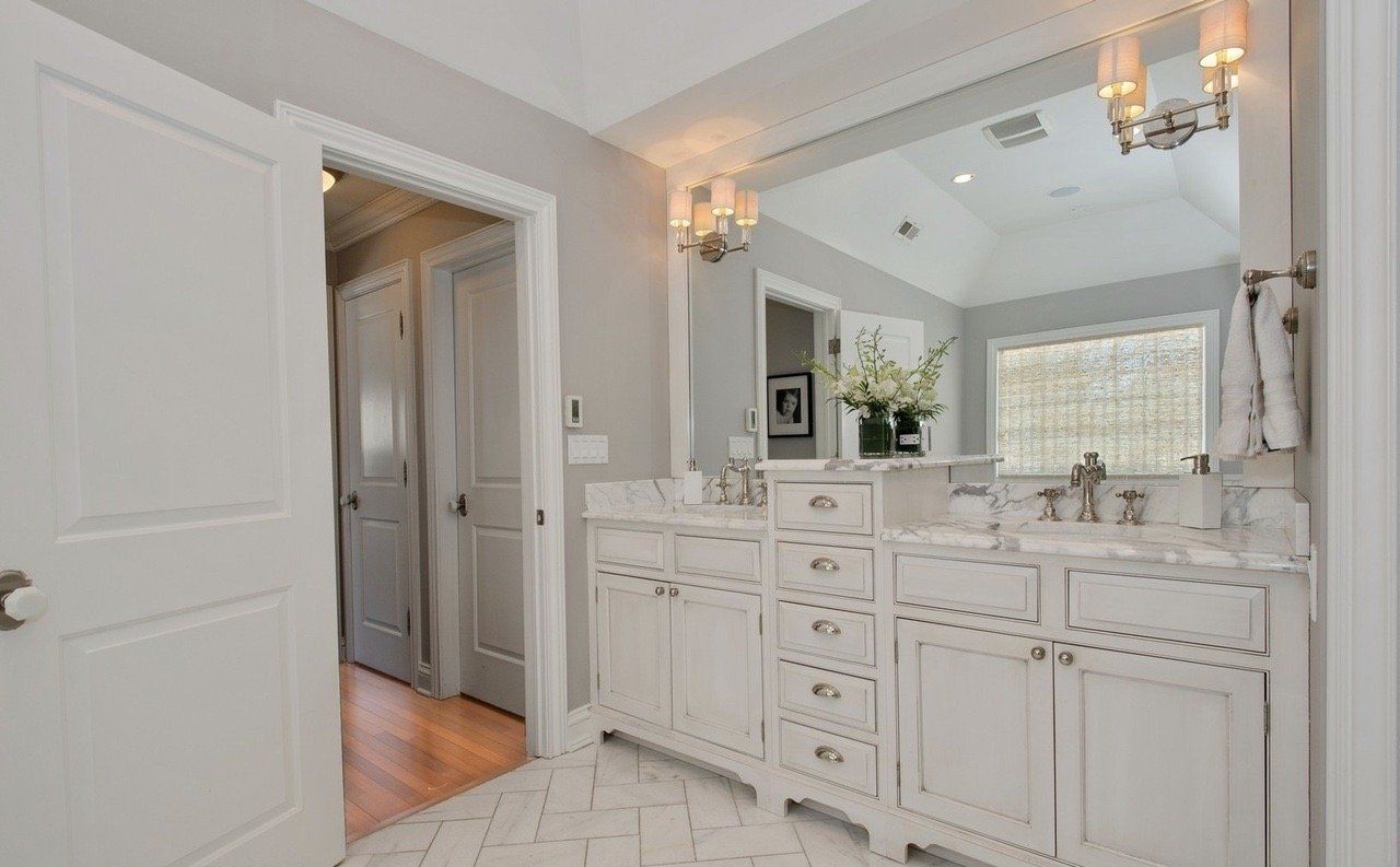 A bathroom with two sinks and a large mirror.