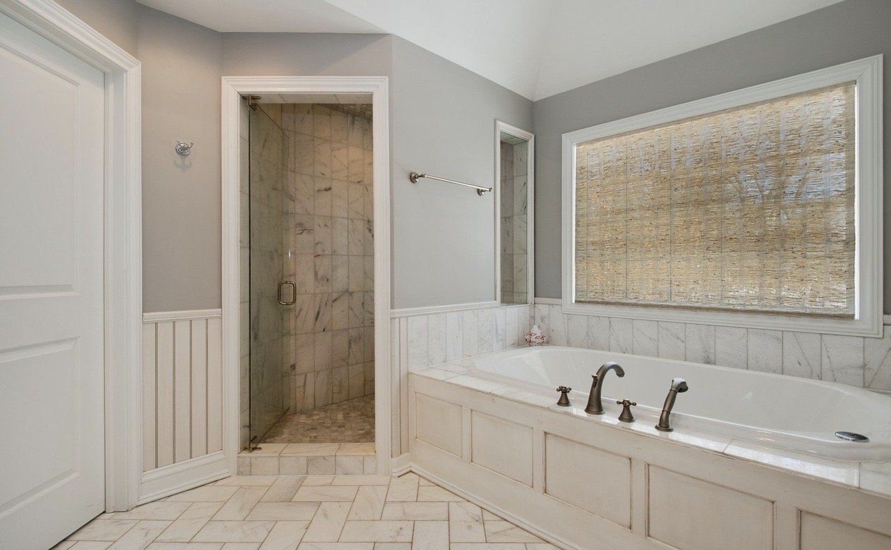 A bathroom with a tub and a walk in shower.