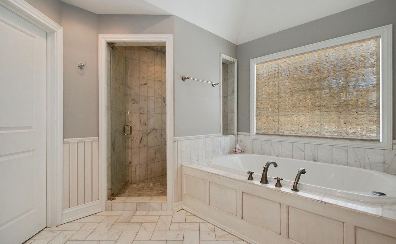 A bathroom with a tub and a walk in shower.