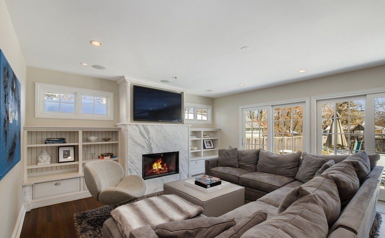 A living room with a large sectional couch and a fireplace.
