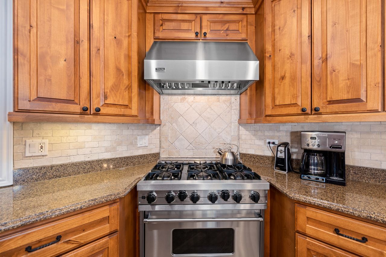 A kitchen with stainless steel appliances and wooden cabinets.