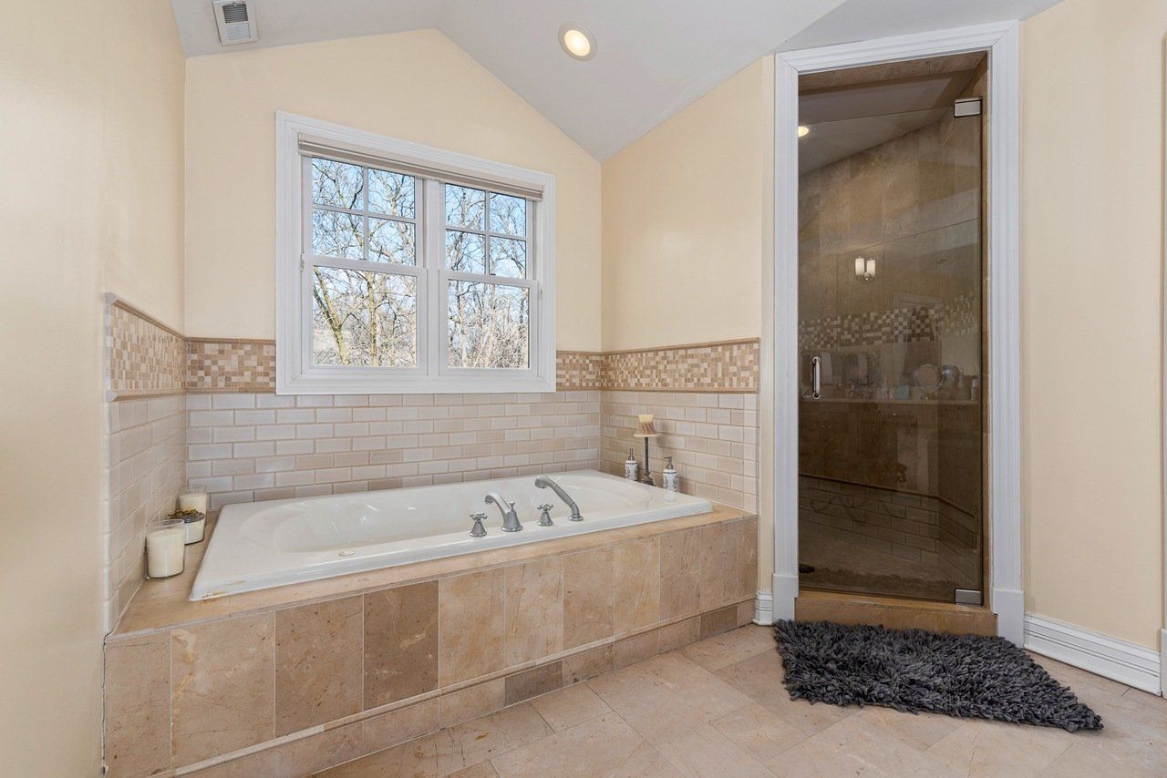 A bathroom with a jacuzzi tub and a walk in shower.