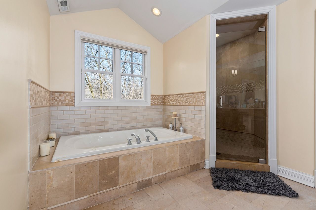 A bathroom with a jacuzzi tub and a walk in shower.