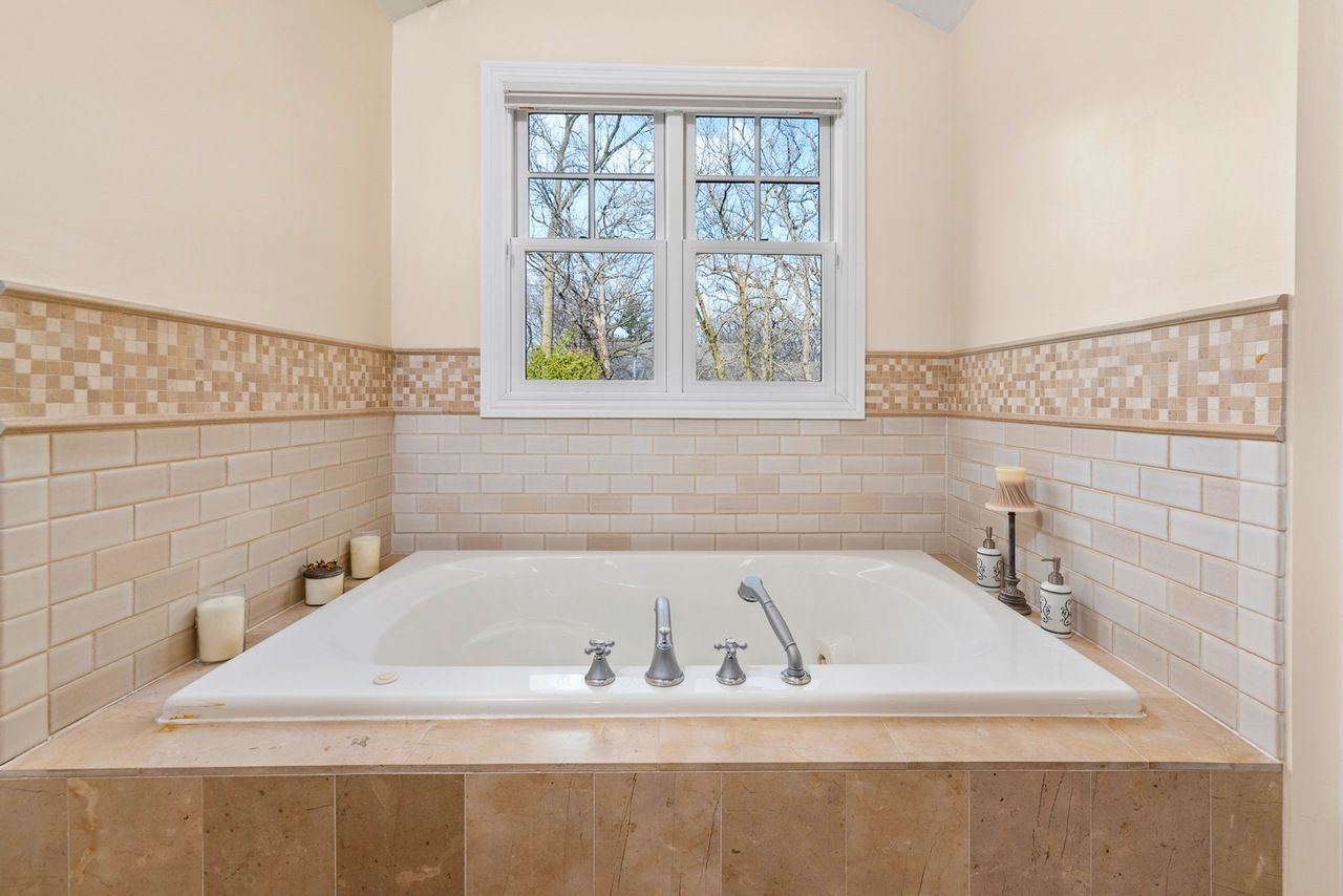 A bathroom with a jacuzzi tub and a window.