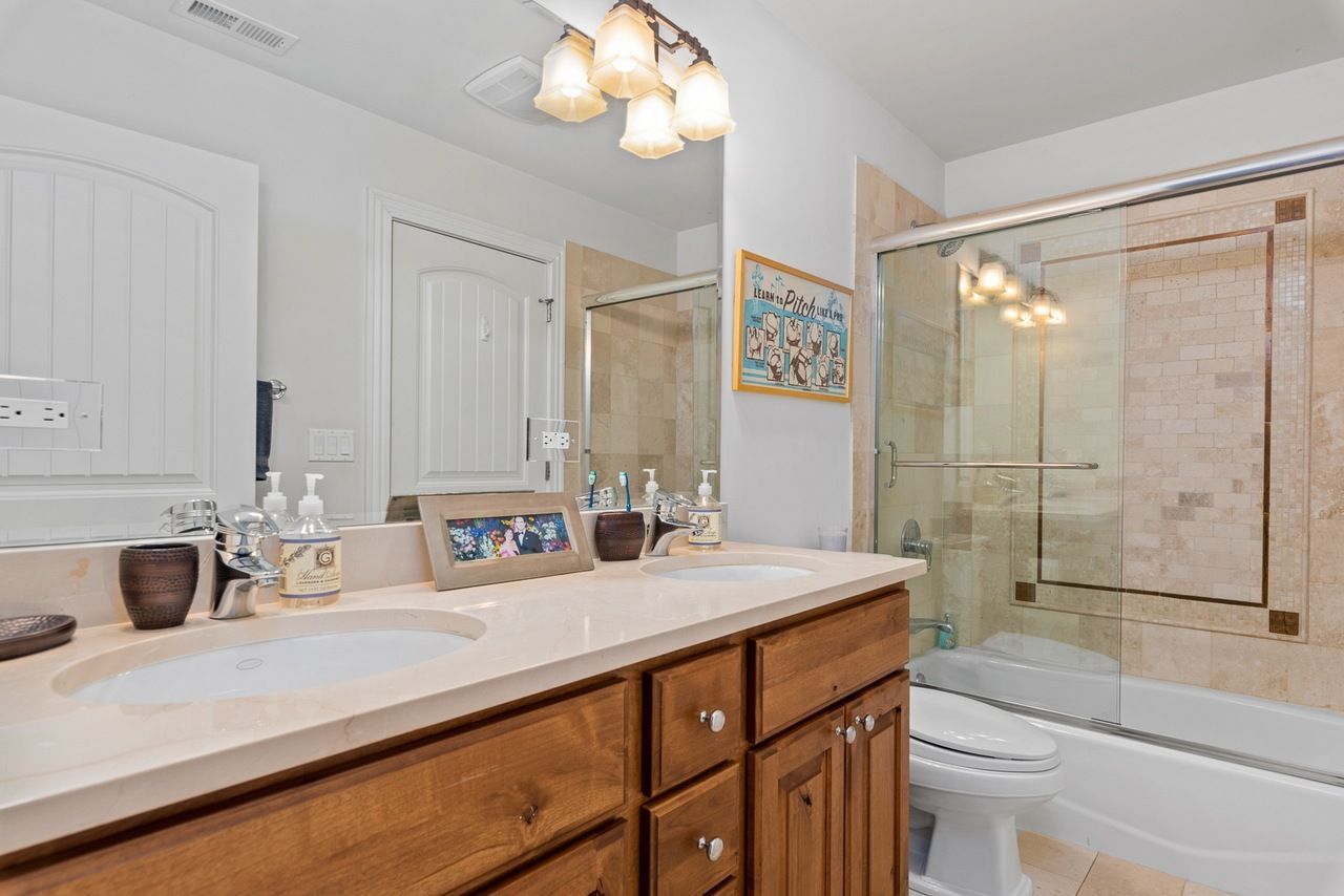 A bathroom with two sinks , a toilet , and a bathtub.
