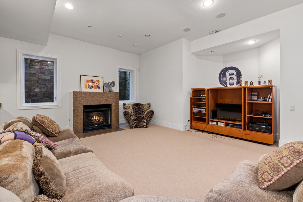 A living room with a fireplace , couch , chair and television.
