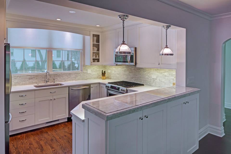 A kitchen with white cabinets , stainless steel appliances , a sink , and a stove.