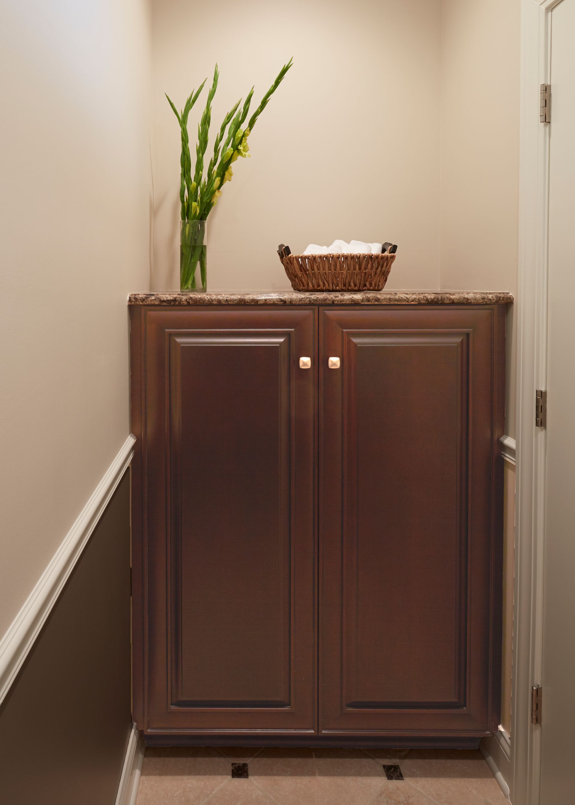 A wooden cabinet with a vase of flowers on top of it.