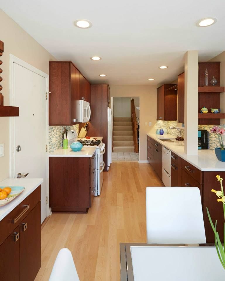 A kitchen with brown cabinets and white counter tops