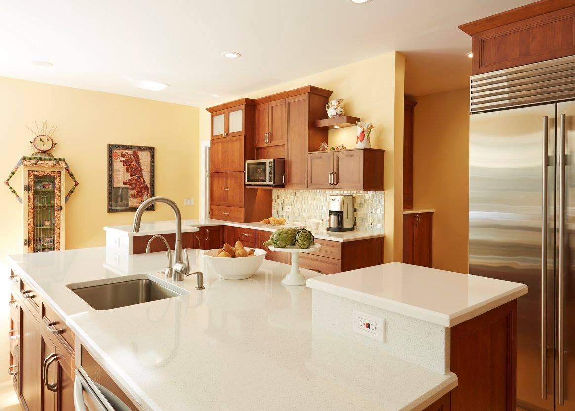 A kitchen with a stainless steel refrigerator and a sink