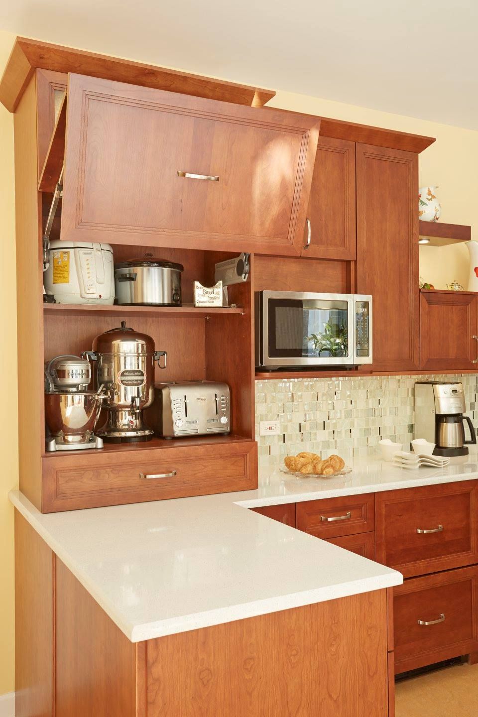 A kitchen with wooden cabinets and a microwave