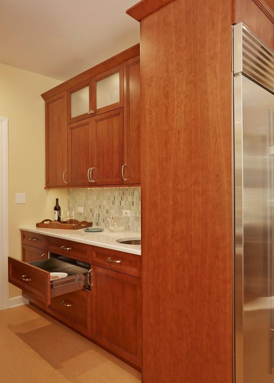 A kitchen with wooden cabinets and a stainless steel refrigerator