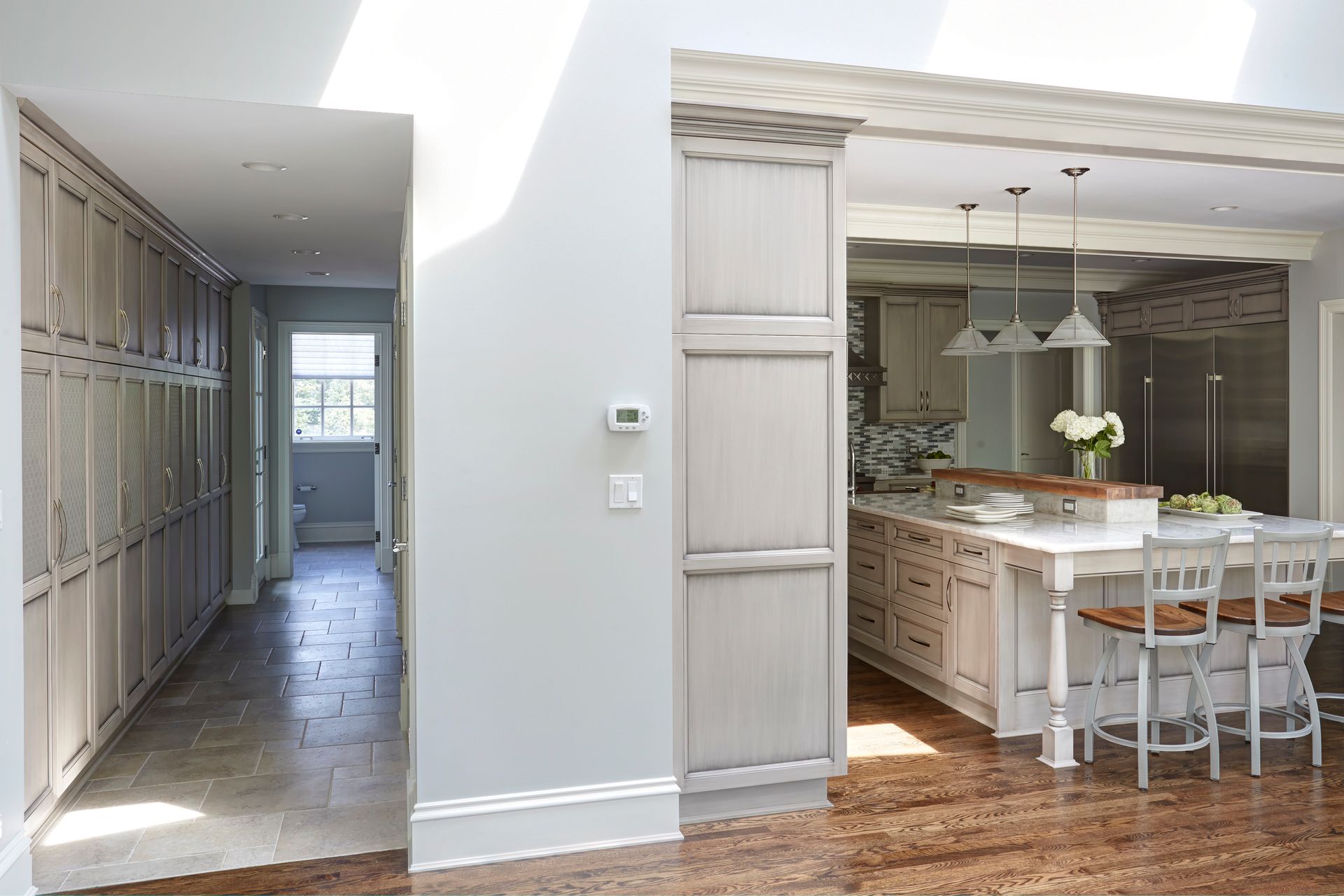 A kitchen with white cabinets and wooden floors