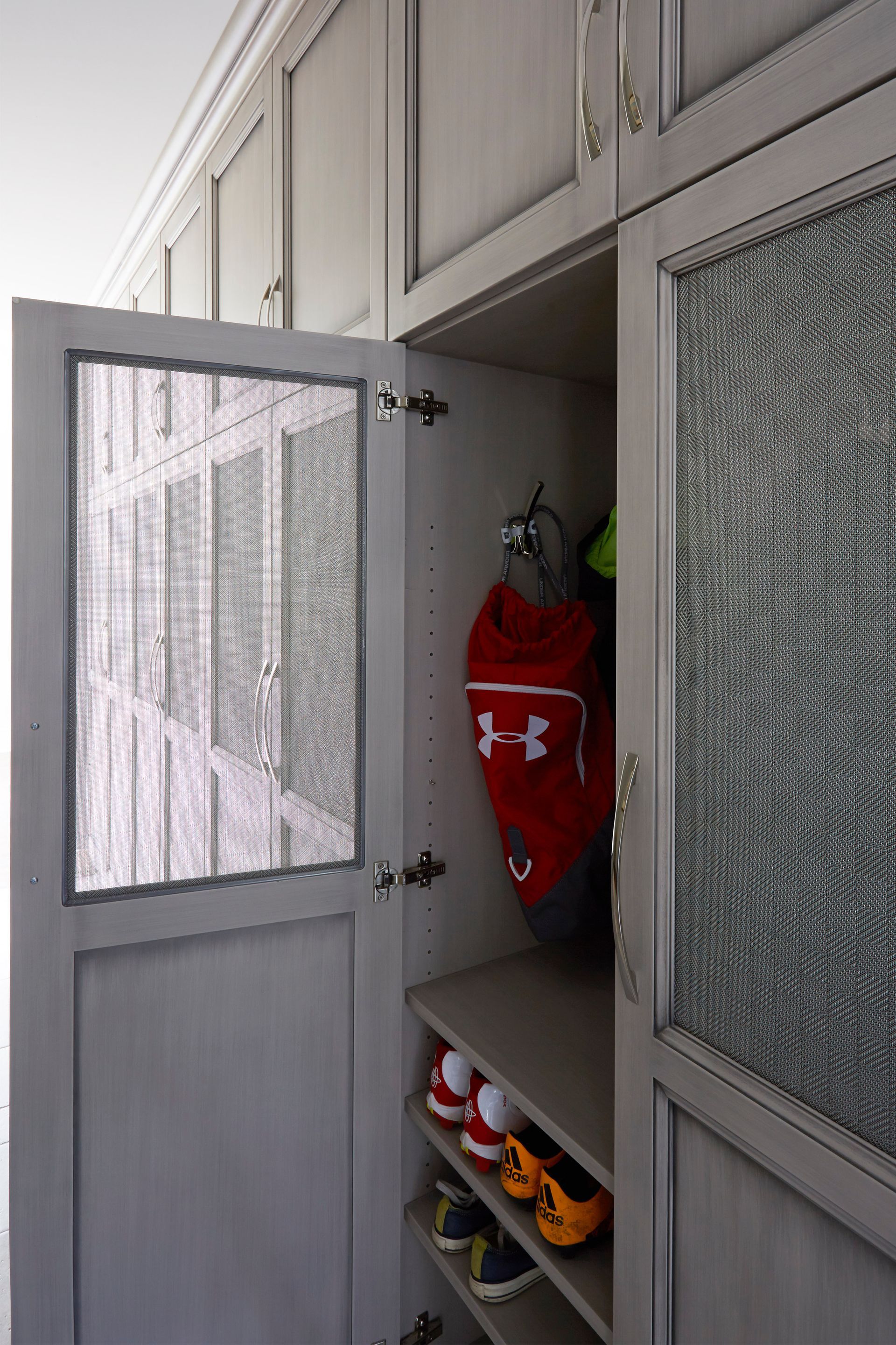 A closet with a door open and a shelf with shoes in it.