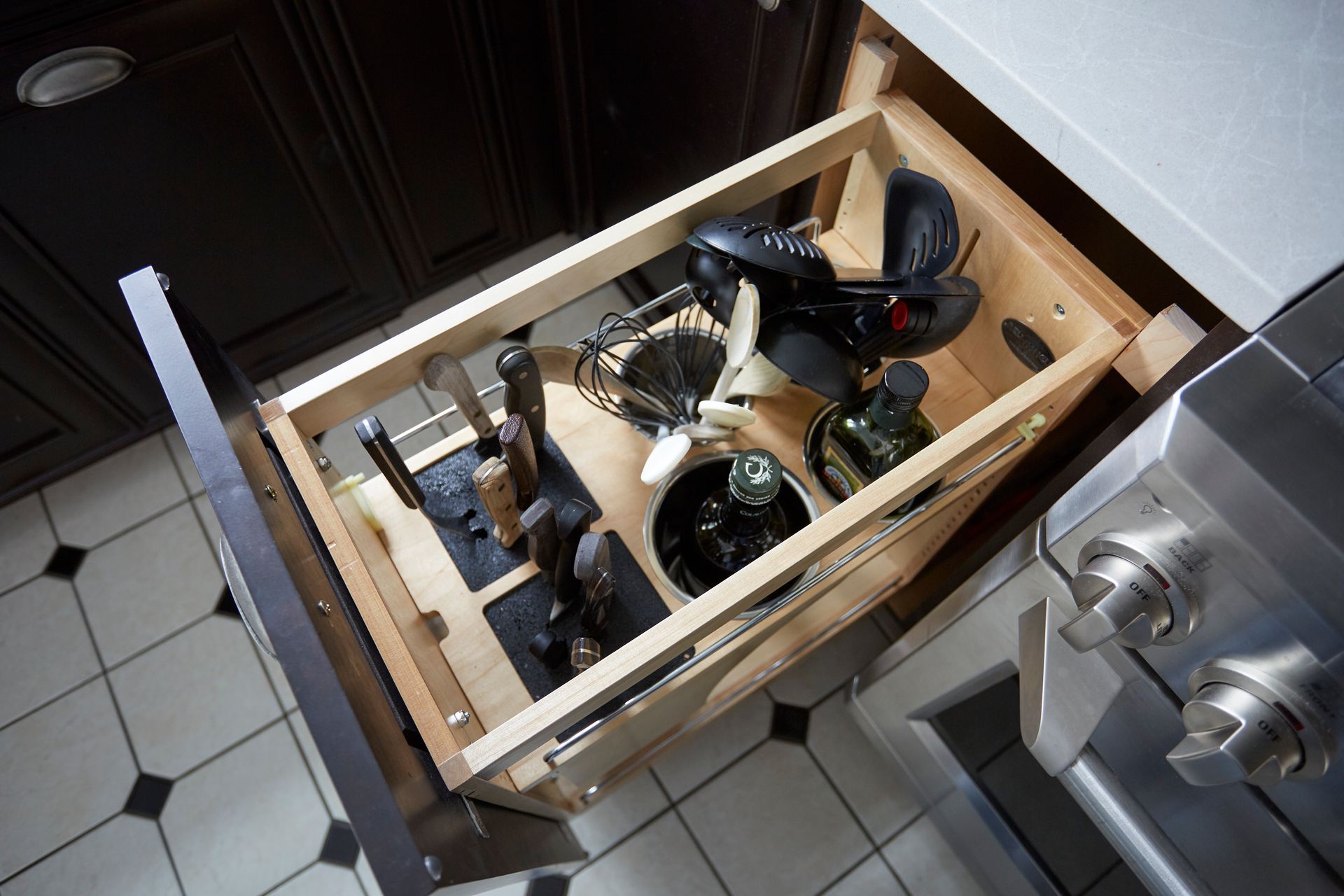 A kitchen drawer filled with utensils and pots and pans