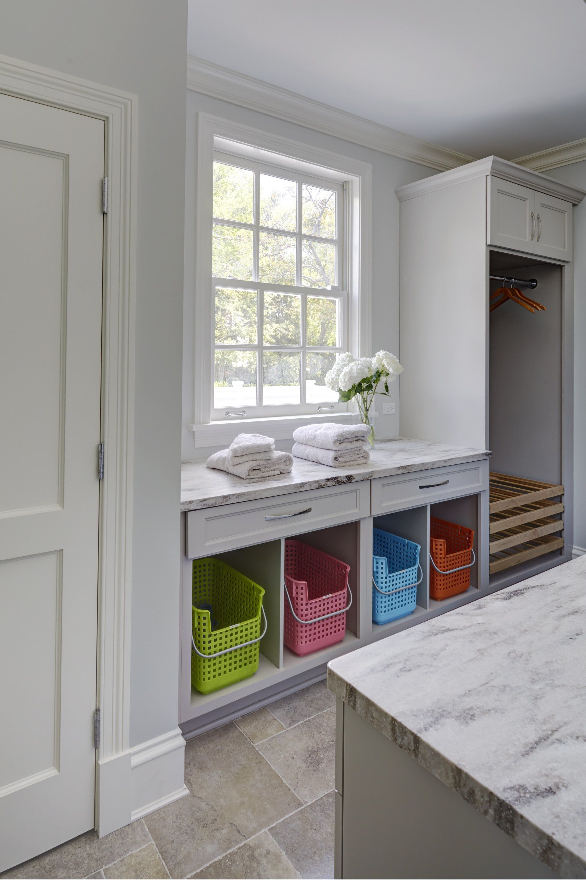A laundry room with lots of baskets and a window.