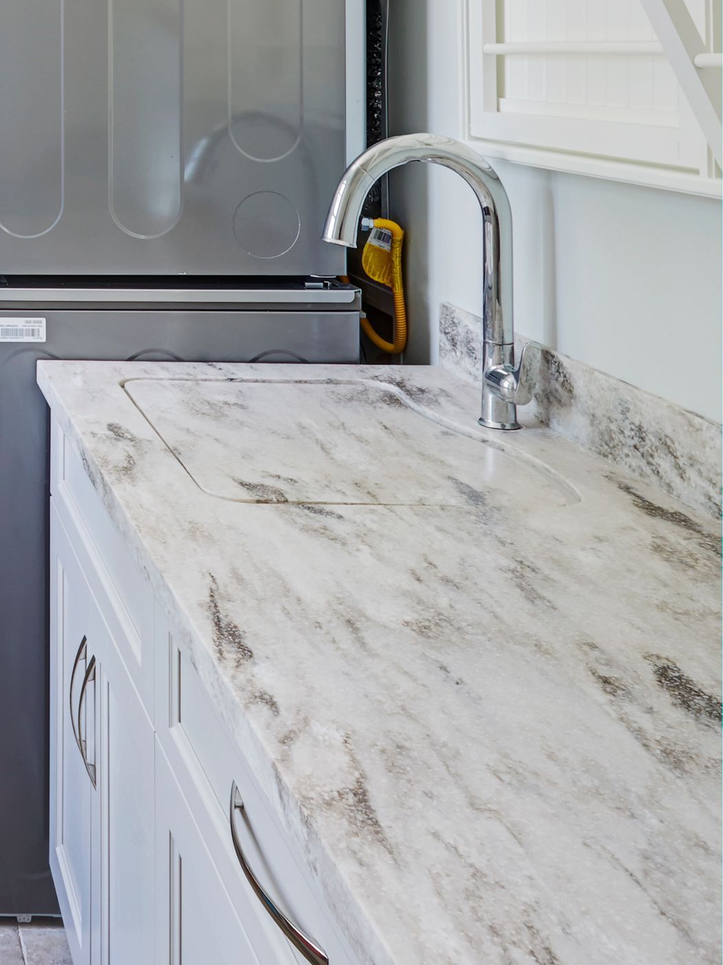 A kitchen counter with a sink and a faucet.
