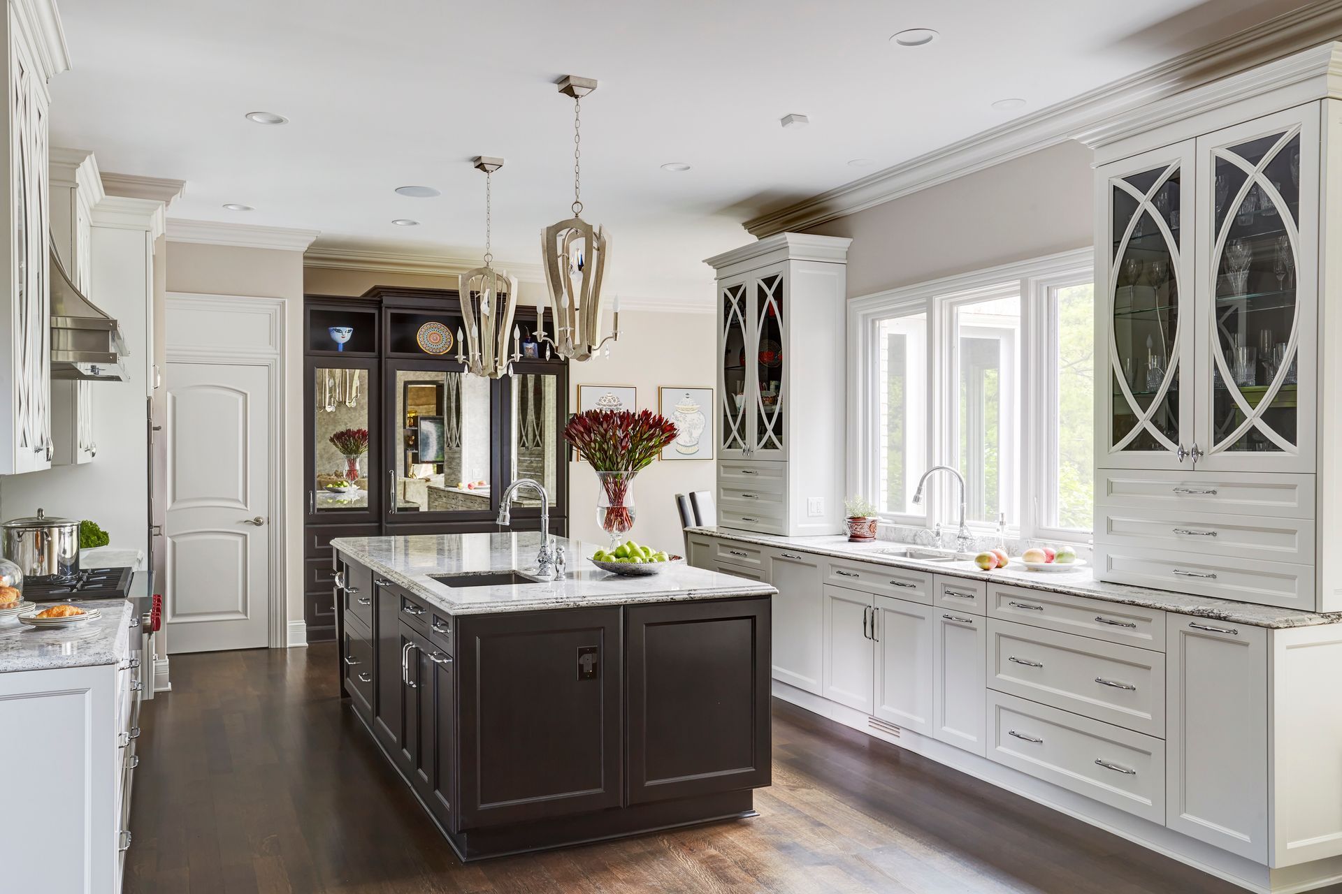 A kitchen with white cabinets and a large island in the middle.