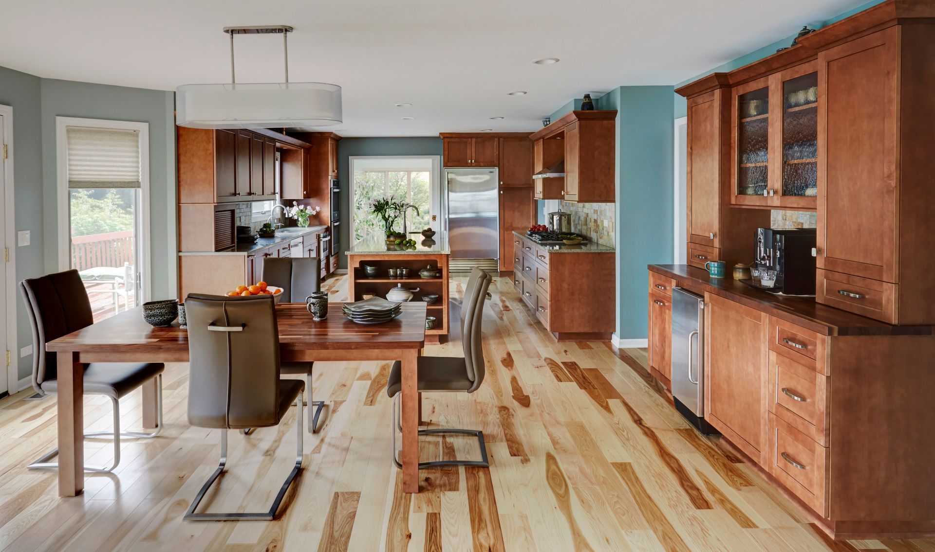 A kitchen and dining room with hardwood floors and wooden cabinets