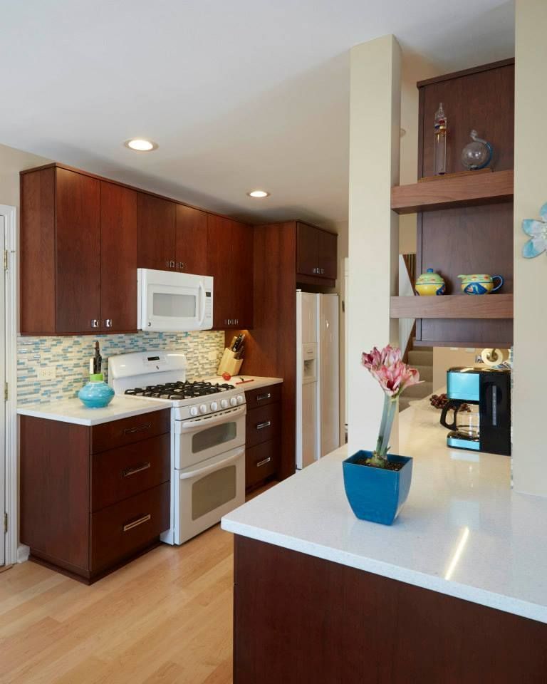 A kitchen with a vase of flowers on the counter