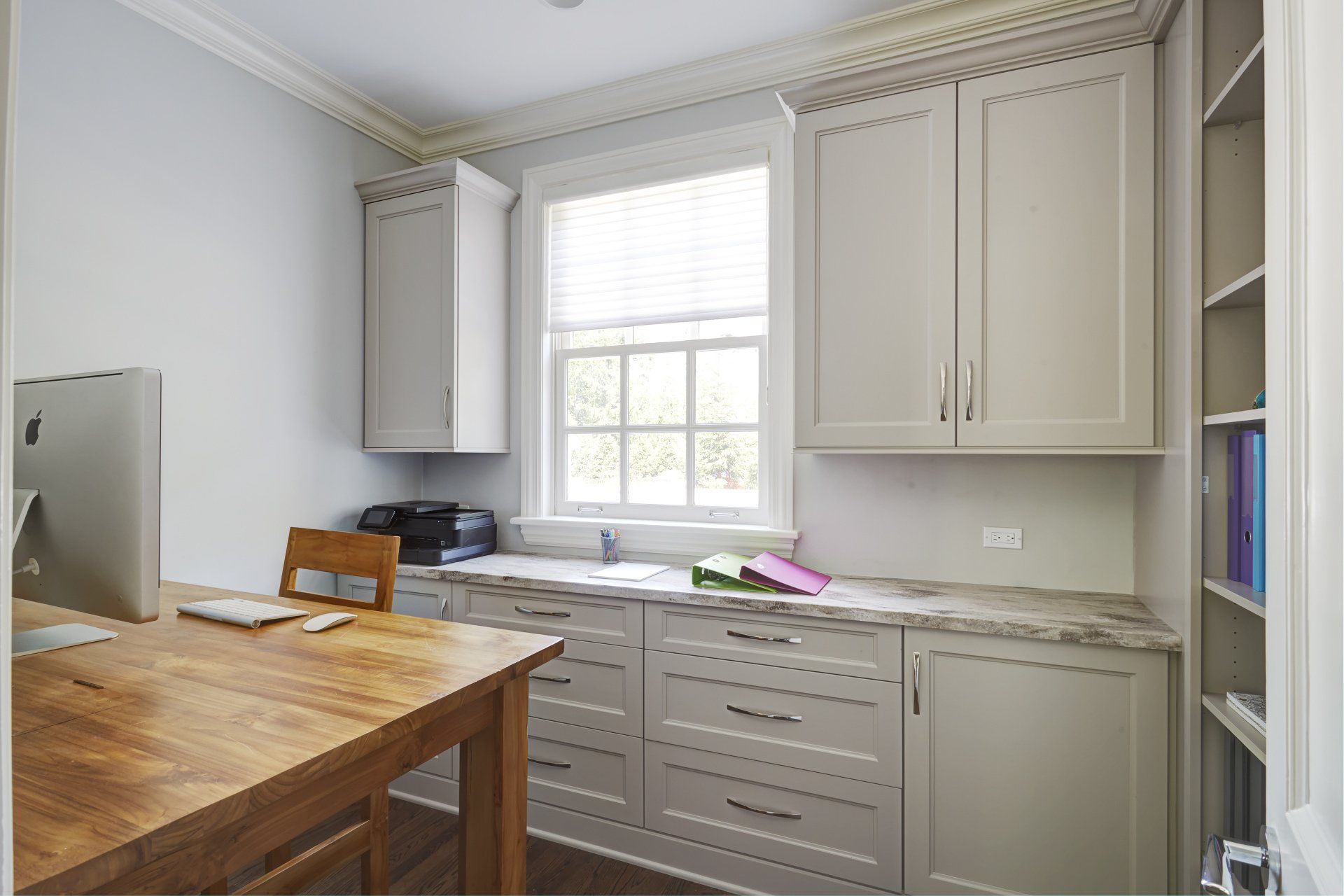 A kitchen with white cabinets and a wooden table