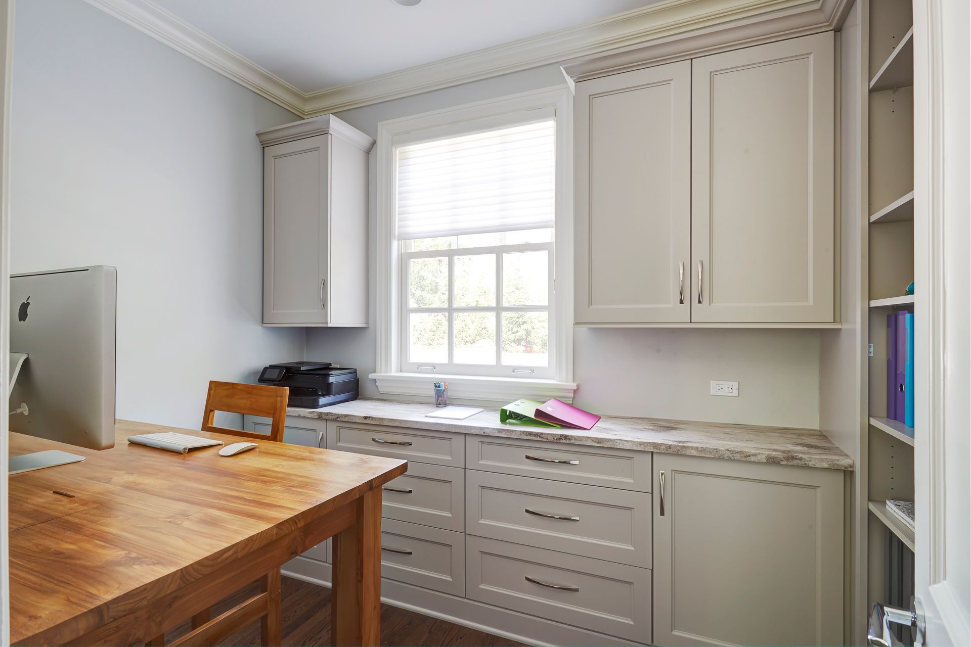 A kitchen with white cabinets and a wooden table