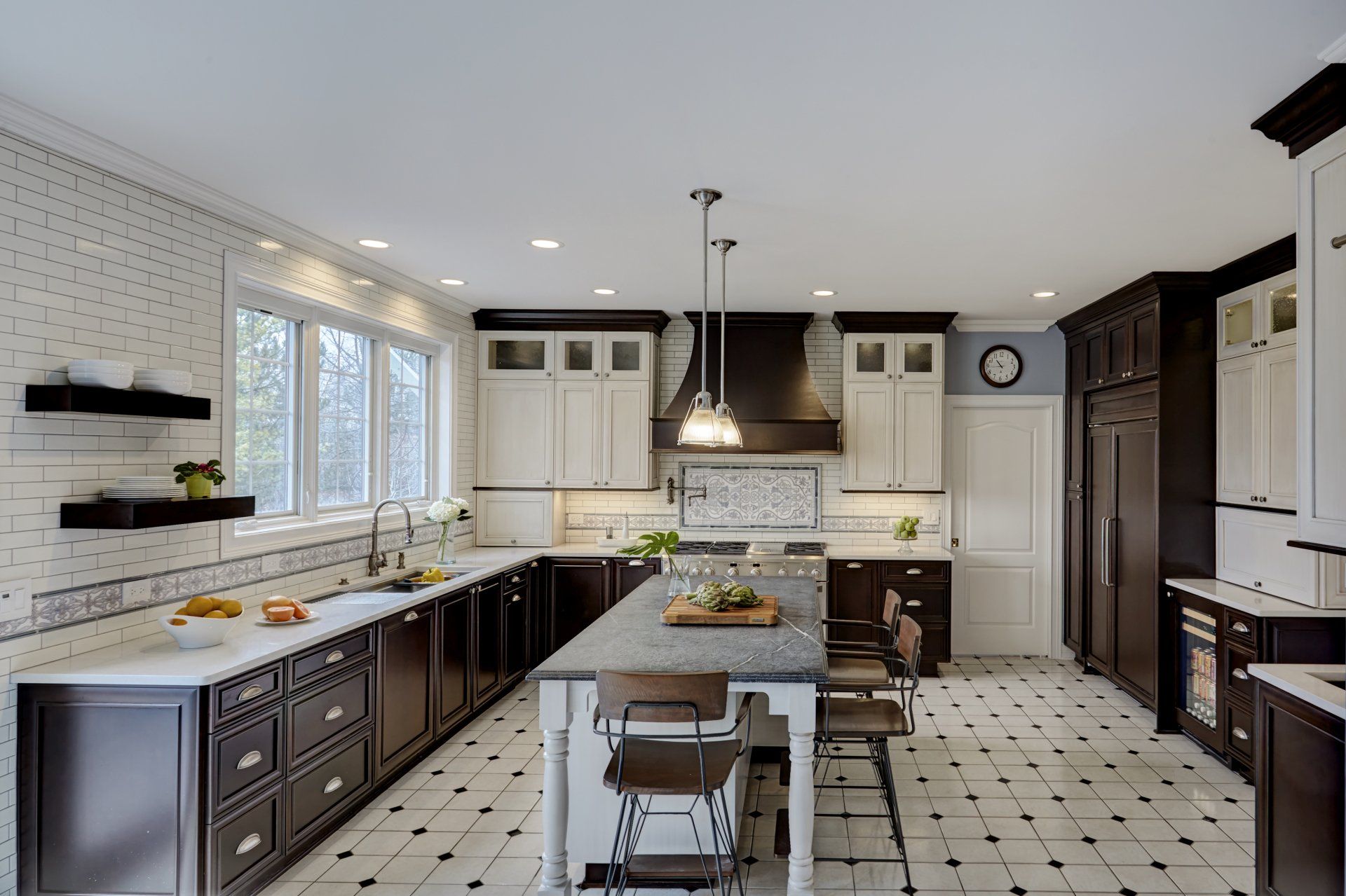 A kitchen with black and white cabinets and a large island.