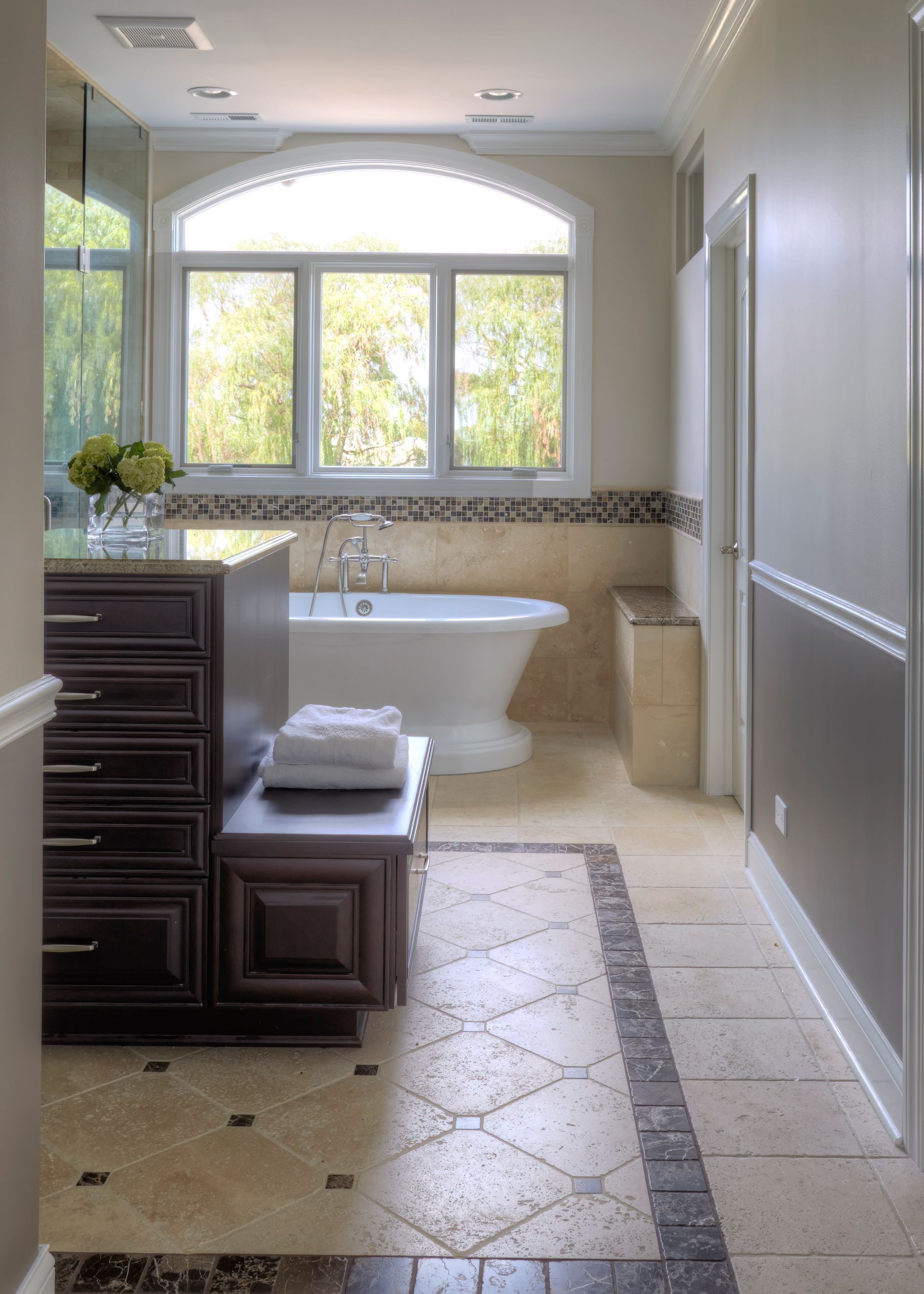 A bathroom with a tub and a large window