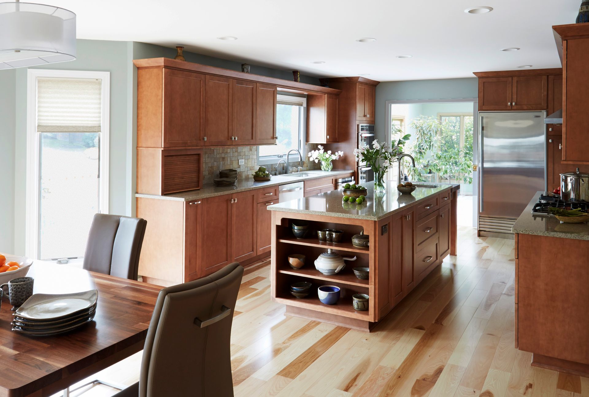 A kitchen with wooden cabinets and a large island in the middle