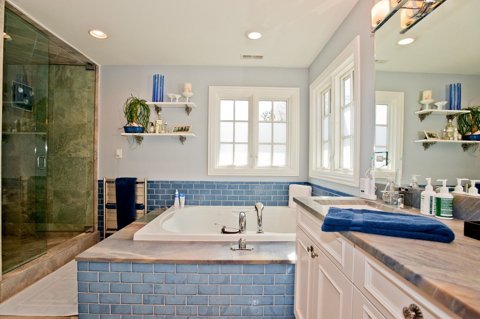 A bathroom with a large tub , sink , and mirror.