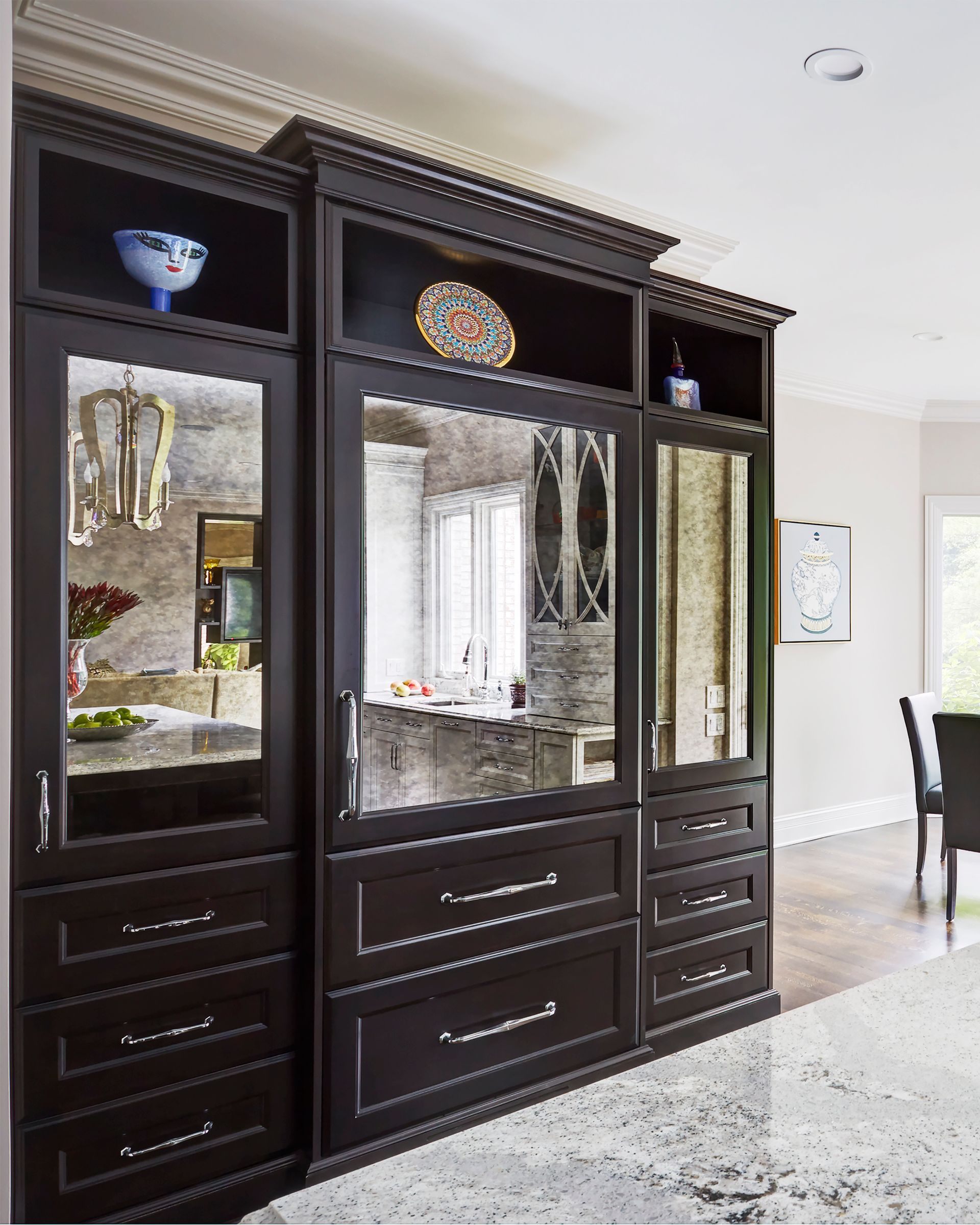 A large cabinet with lots of drawers and mirrors in a room.